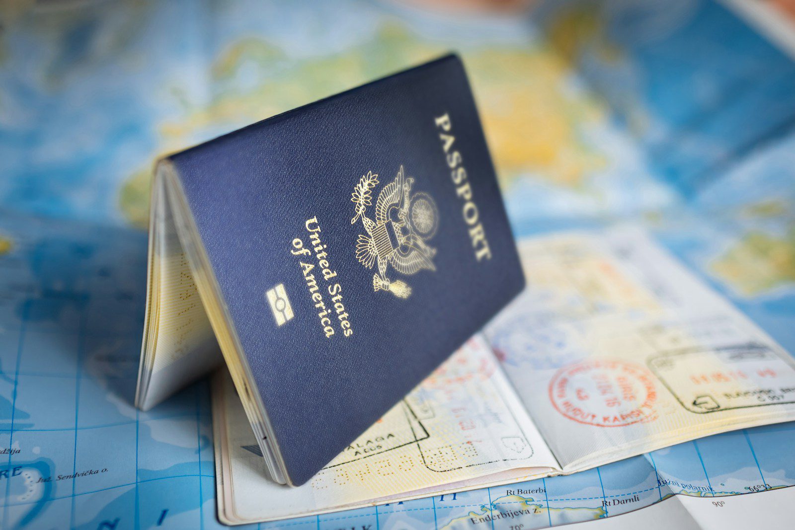 Thailand's ฿3 Million Property Visa Is Suspended. Here's Why I Wouldn't Panic. 6 Passport open on a world map, planning a long term residence visa